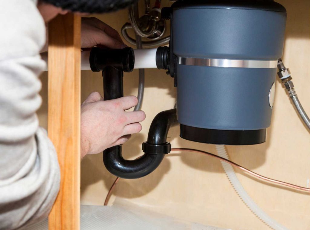 Plumber repairing garbage disposal