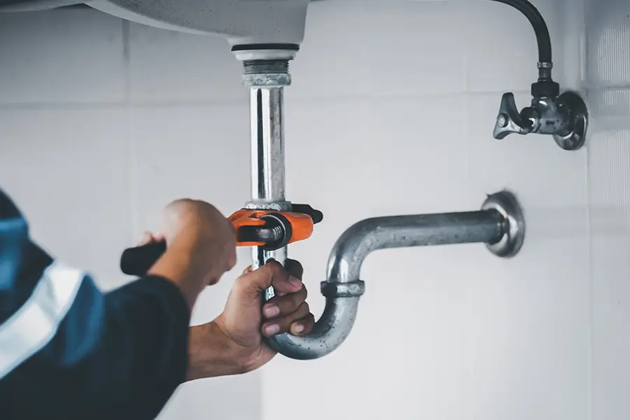 Plumber Tightening Sink Pipe