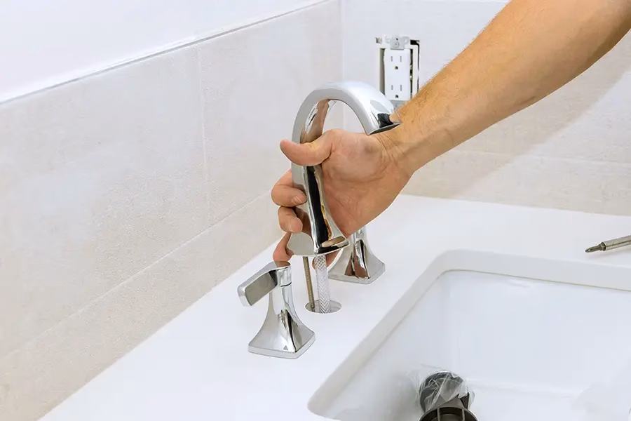 Plumber examining faucet contamination risk