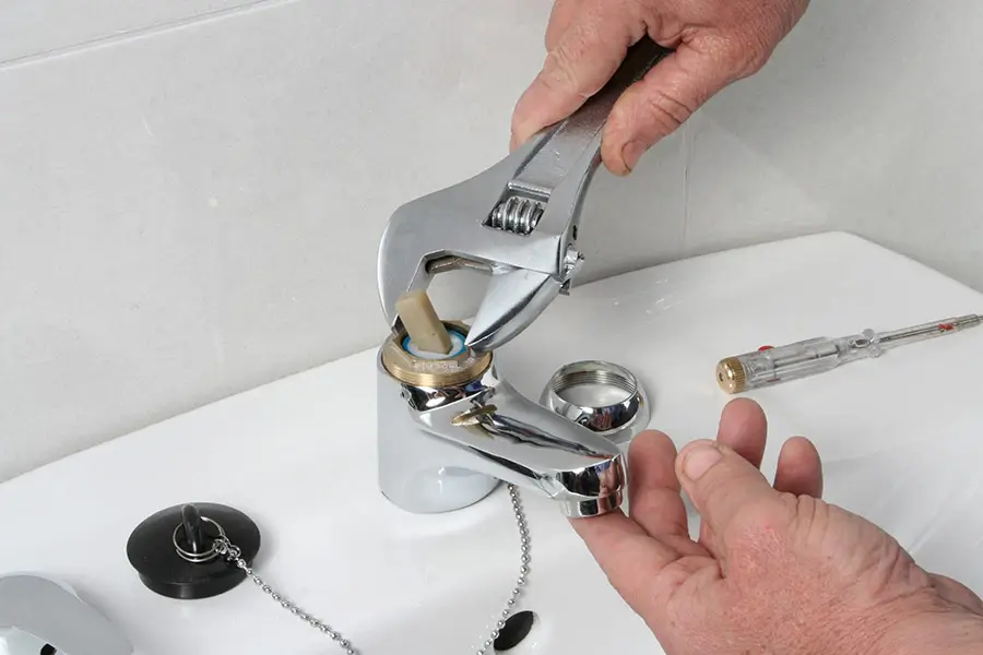 Plumber adjusting a faucet